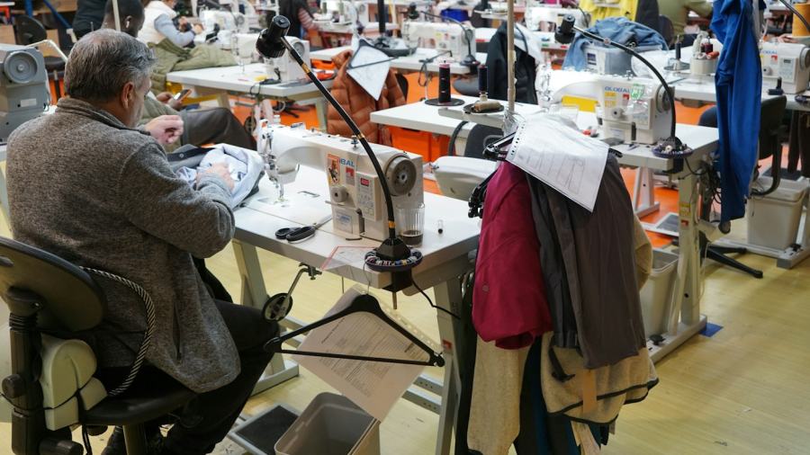 Operator working at a sewing station on a garment production floor
