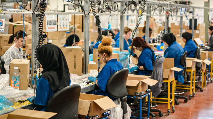Manual assembly line with operators working at individual stations