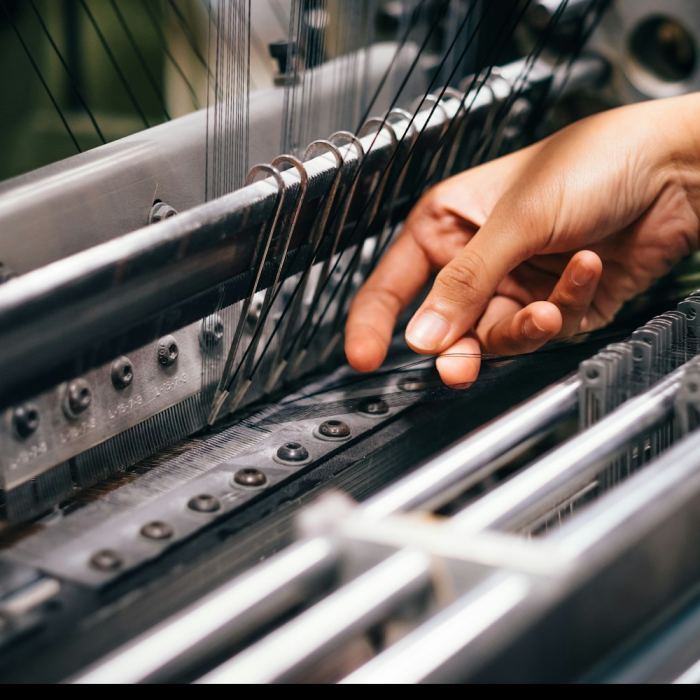 Close-up of an operator threading a production machine